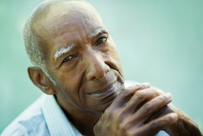 senior man with hands on chin