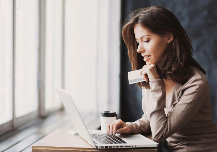 woman holding credit card on laptop