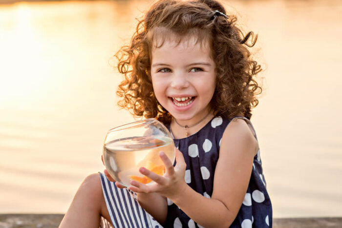 Little girl at lake with goldfish